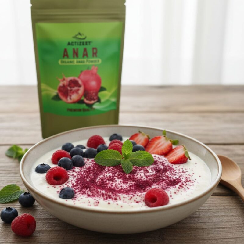 A bowl of yogurt topped with fresh berries, mint, and a dusting of ACTIZEET Anar powder.