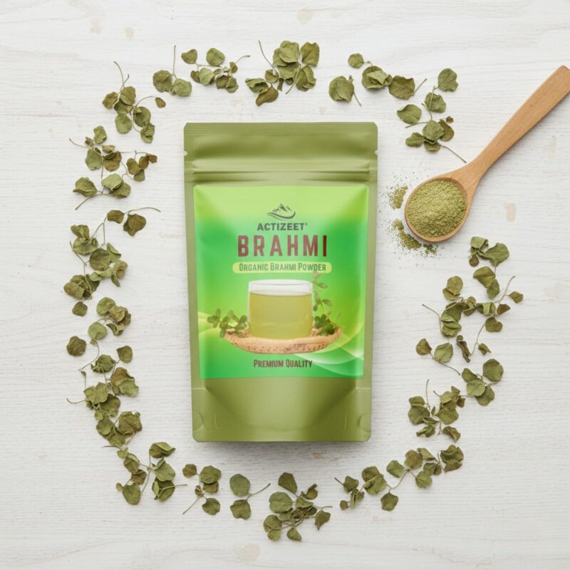 Top-down flat lay of Brahmi powder pouch with dried leaves and a wooden spoon.