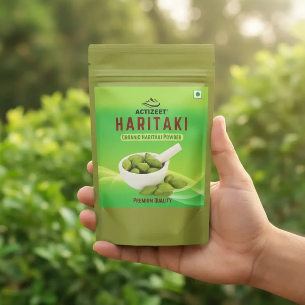Indian hand holding Haritaki pouch with blurred greenery background